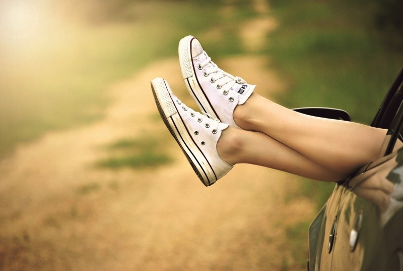 woman-in-canvas-shoes-relaxing-in-car-on-dirt-road